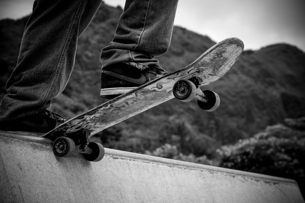 Black and white image of close-up skateboard action on ramp, capturing the thrill of skateboarding.
